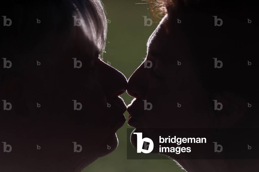Silhouette of man and woman head profile . Couple kissing.  France.