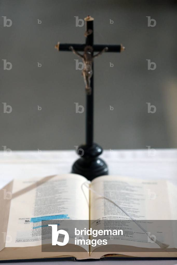 Crucifix, open bible on altar. Catholic church.  France.