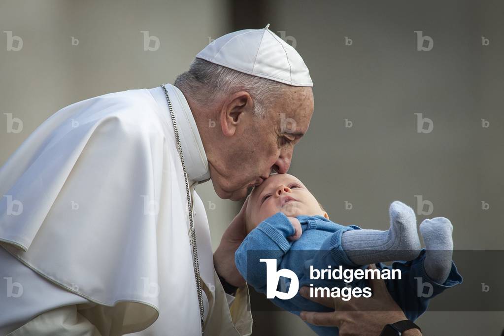 Pope Francis kisses a child as he arrives for his weekly general audience in St. Peter's Square at the Vatican, 2019 (photo)