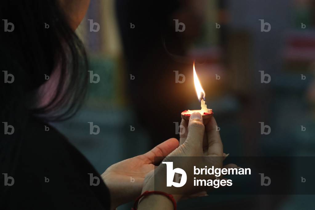 Sri Mahamariamman Hindu Temple, Woman holding oil lamp during Diwali festival of light, Kuala Lumpur, Malaysia (photo)