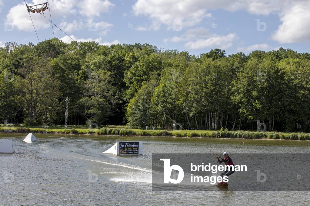 Young man wakeboarding in Damville, France.