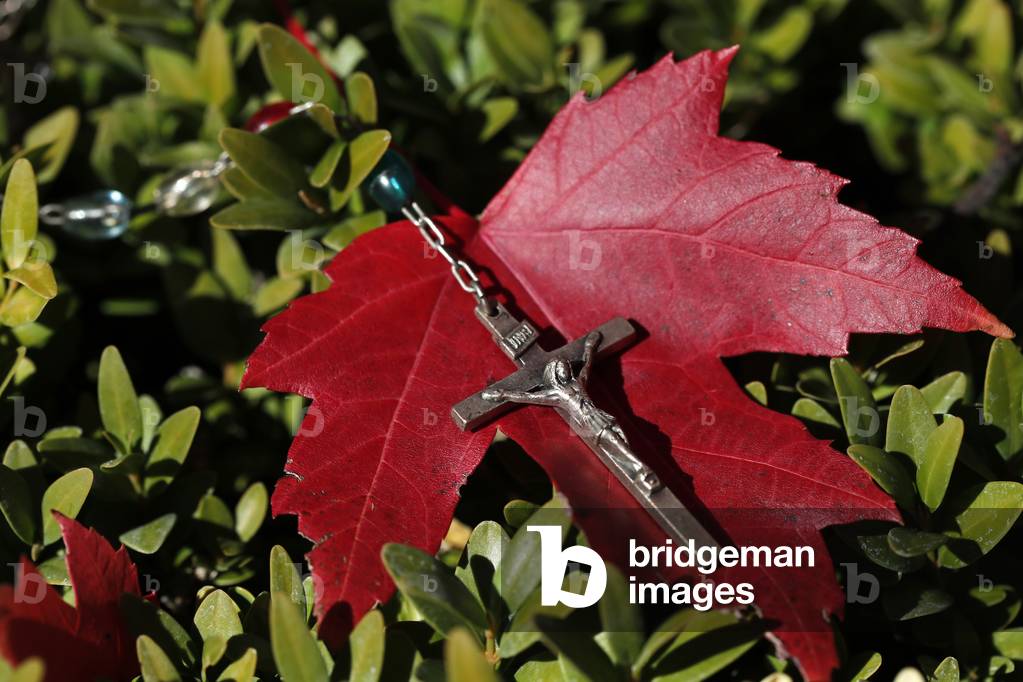 Catholic rosary on fall red leaf. Autumn.  France.