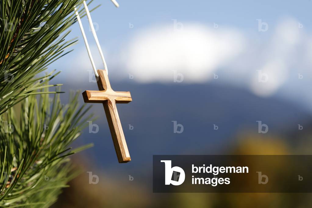 Christian wooden  cross on  fir tree branches.  Mont Blanc massif.  France.