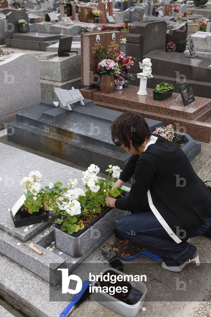 Grave maintenance by the dead person's daughter, Saint-Ouen, France