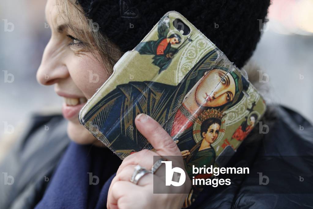 Catholic convert with cell phone in Massy, France (photo)