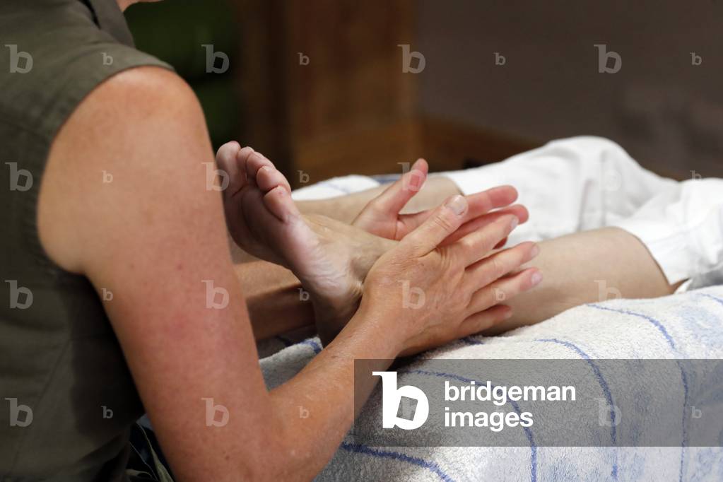 Traditional chinese medecine. Foot reflexology. Masseur pushing on special points on the foot, massage treatment France.