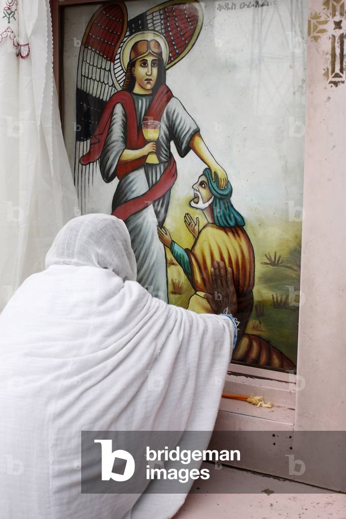 Woman touching an icon in Saint Urael church, Addis Abeba, Ethiopia