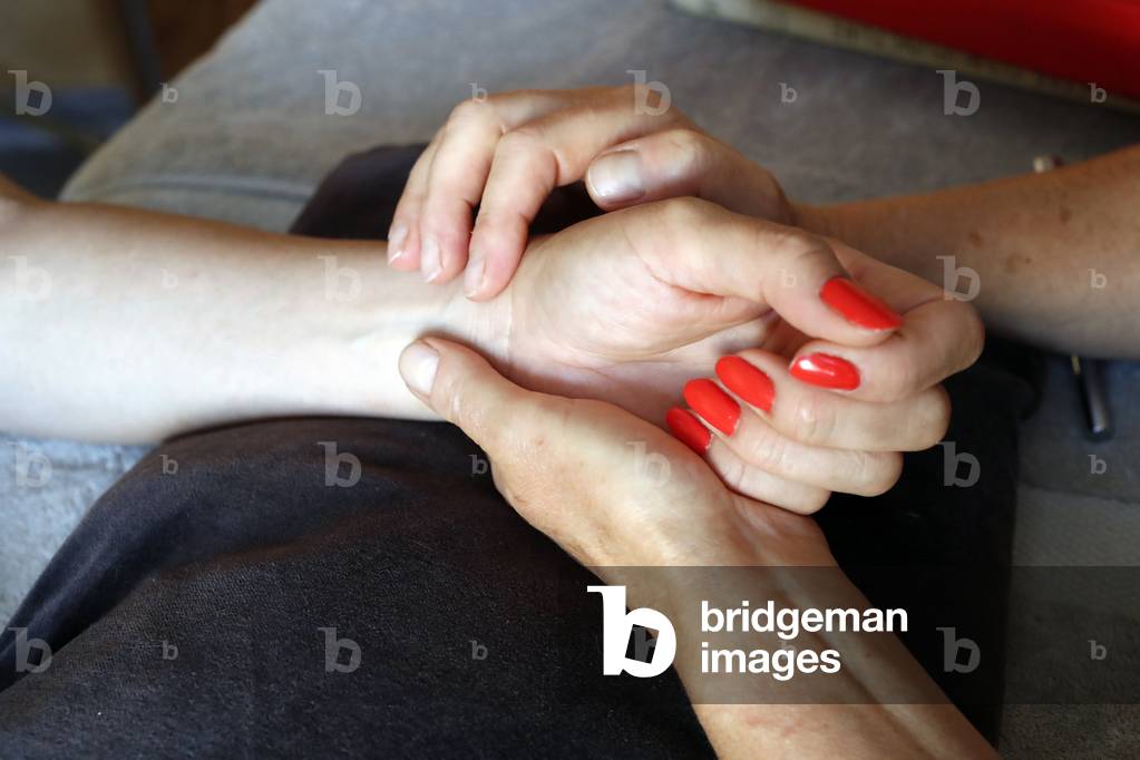 Traditional chinese medecine.  Practitioner checking pulse of young woman to define disease.  France.