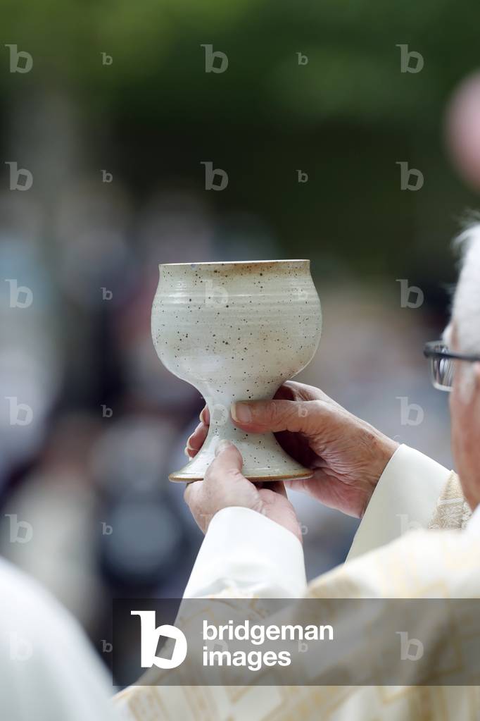 Catholic church during covid-19 epidemic. Sunday mass.  Priest at eucharistic celebration.  Sanctuary of La Benite Fontaine. France.