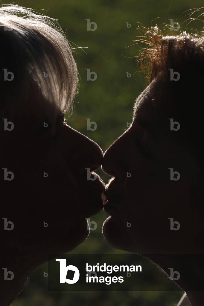 Silhouette of man and woman head profile . Couple kissing.  France.