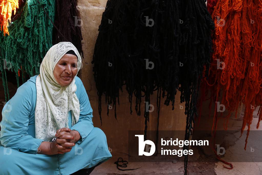 Woman sitting in a wool factory in Marrakesh medina (old city), Morocco (photo)