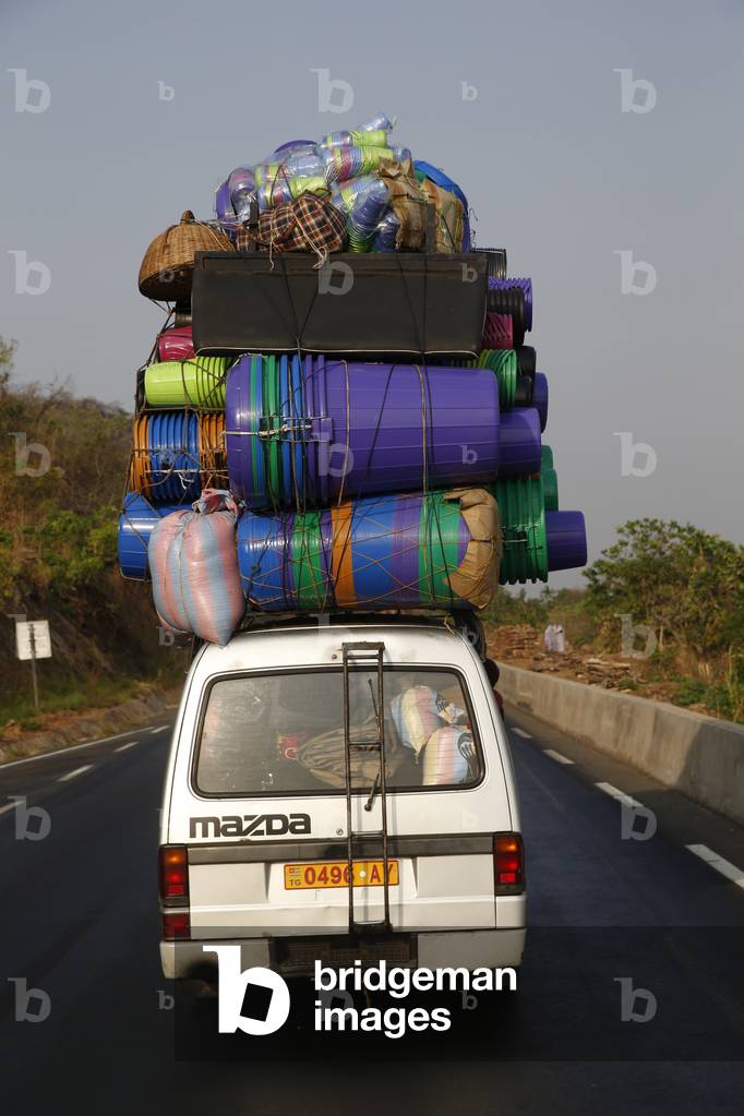 Overloaded minibus on a road in Togo, 2019 (photo)