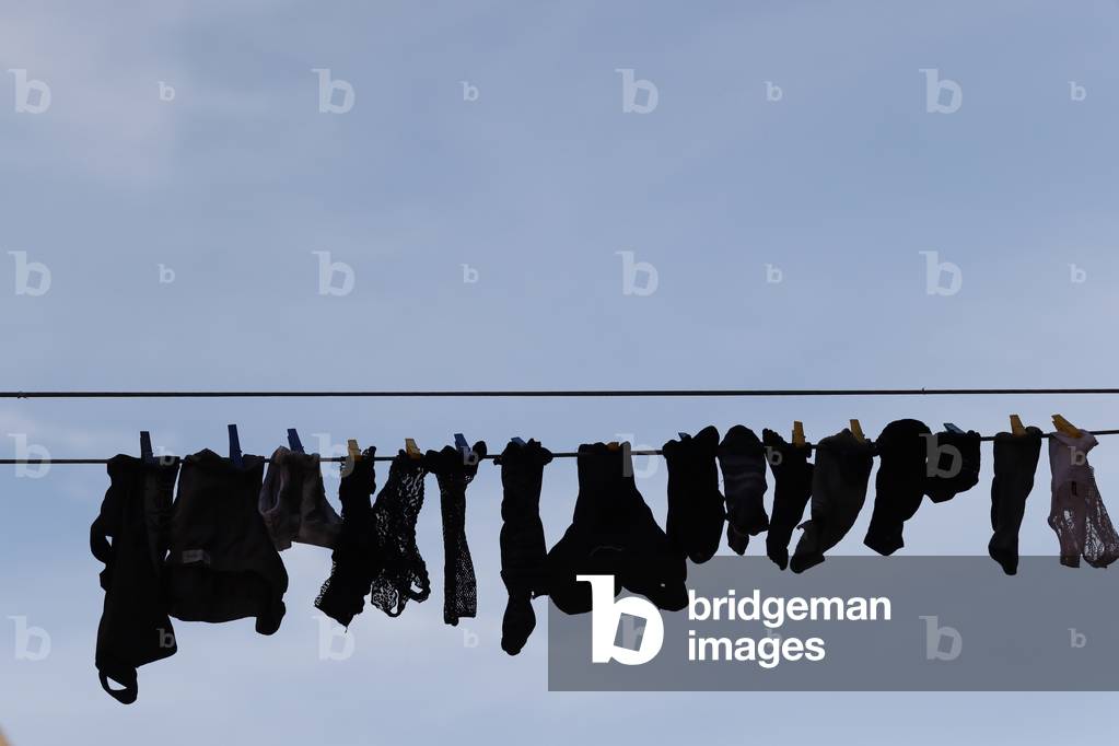 Typical view the streets of Venice washed clothes drying on cords outside the building.