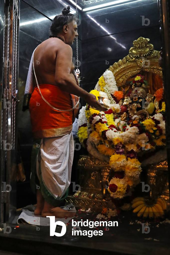 Court Hill Ganesh Temple, Hindu priest doing puja worship, Kuala Lumpur, Malaysia (photo)