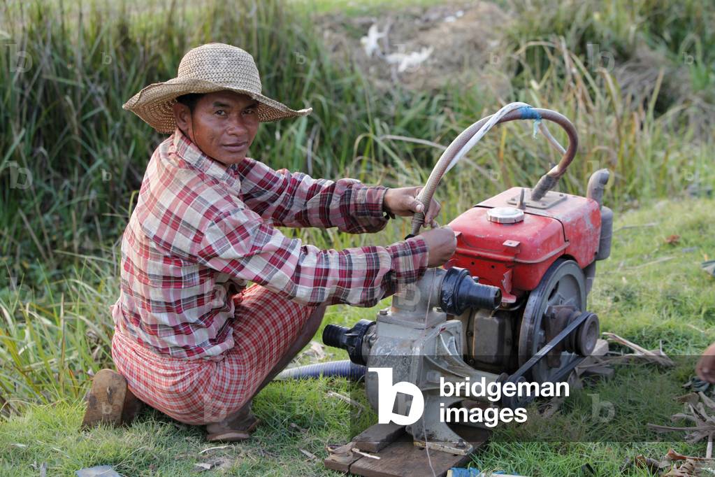 Cambodian farmer using a motor-pump Cambodge