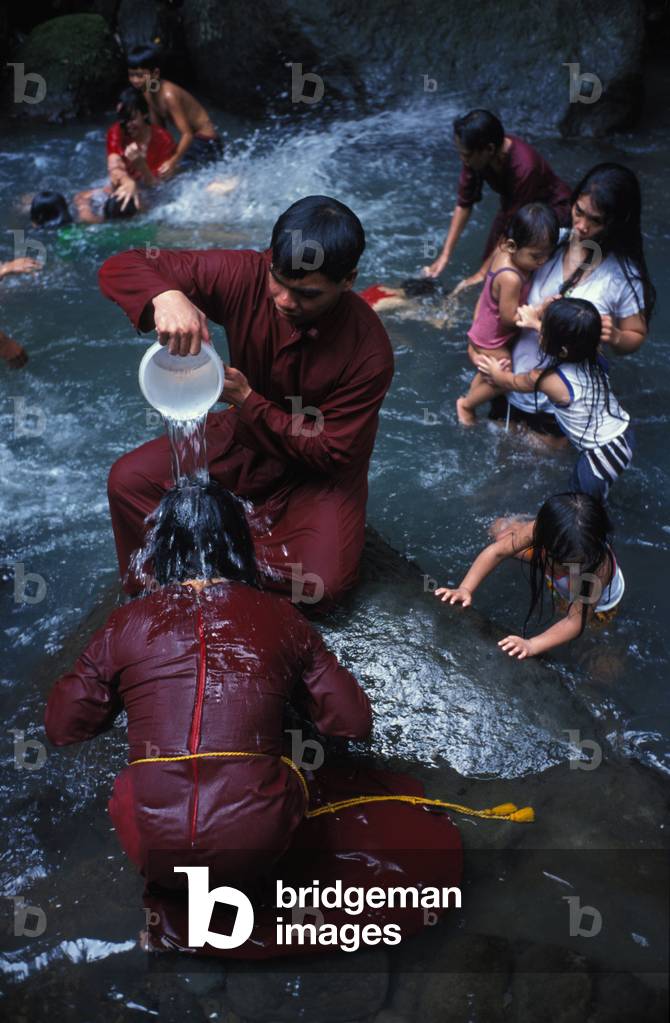 Filipino pilgrim bathing in Santa Lucia holy water at the foot of Mount Banahaw during Lent, Quezon, Philippines