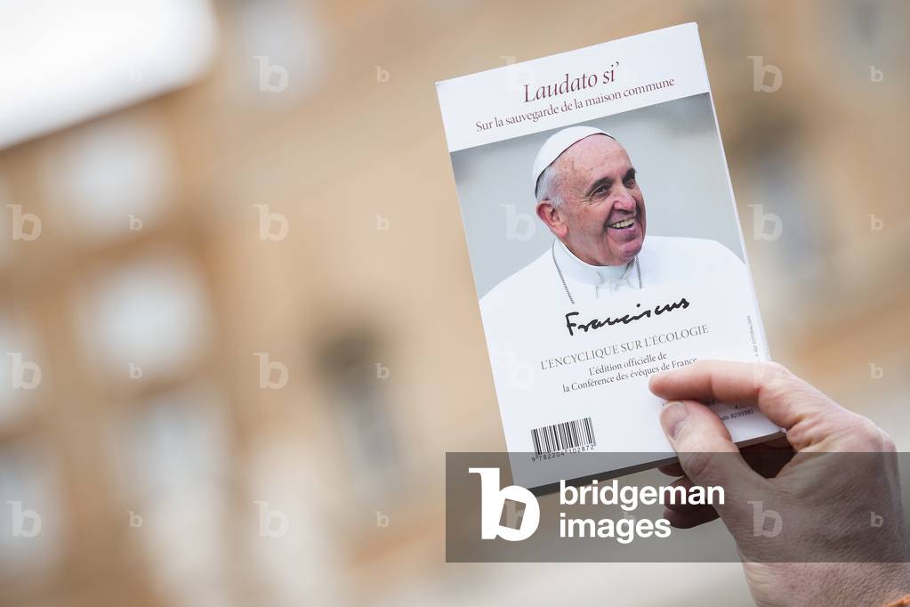 A Man holds Pope Francis's book Laudato Si in Vatican City, 2016 (photo)