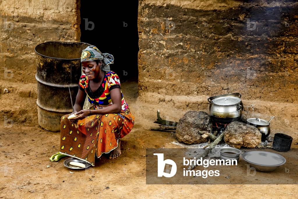Boy cooking outside her home in a village near Daloa, Ivory Coast, 2017 (photo)