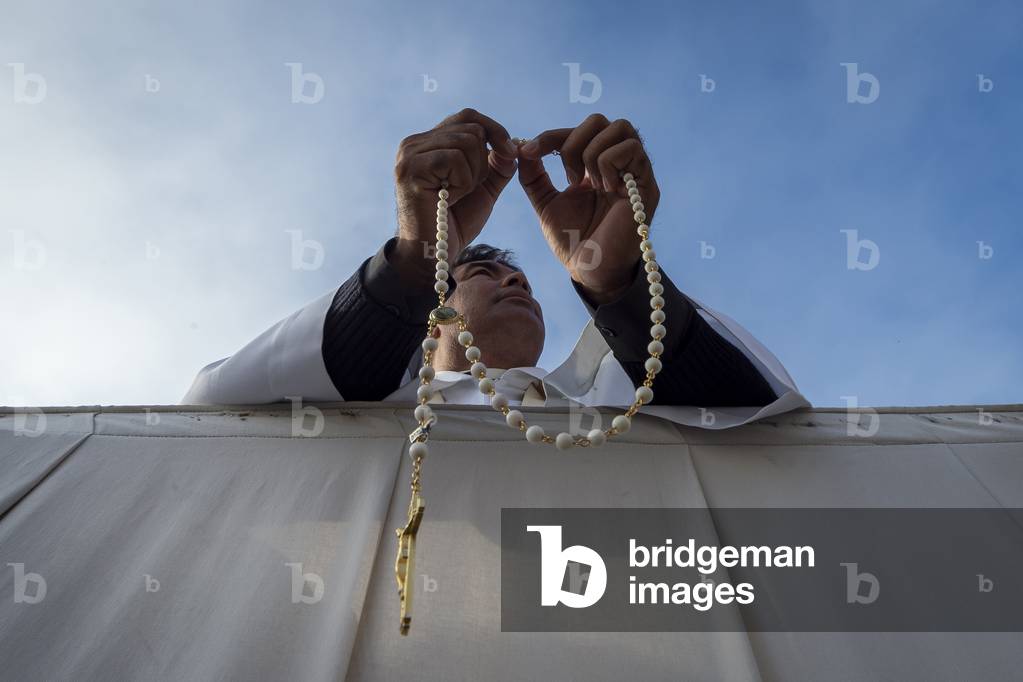 A Priest praying the holy rosary during a Canonization Holy Mass in Saint Peter's square at the Vatican.