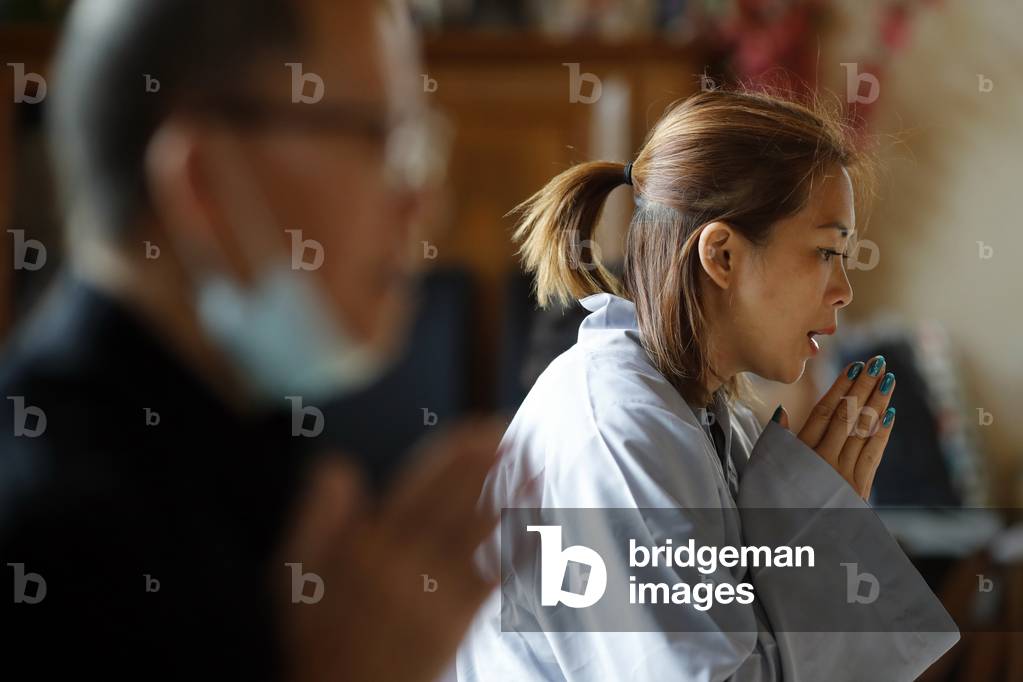 Tu An Buddhist temple. Woman praying  at buddhist ceremony.  France.