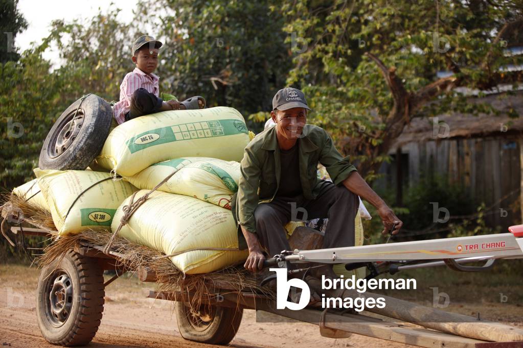 Father and son transporting bags Cambodge