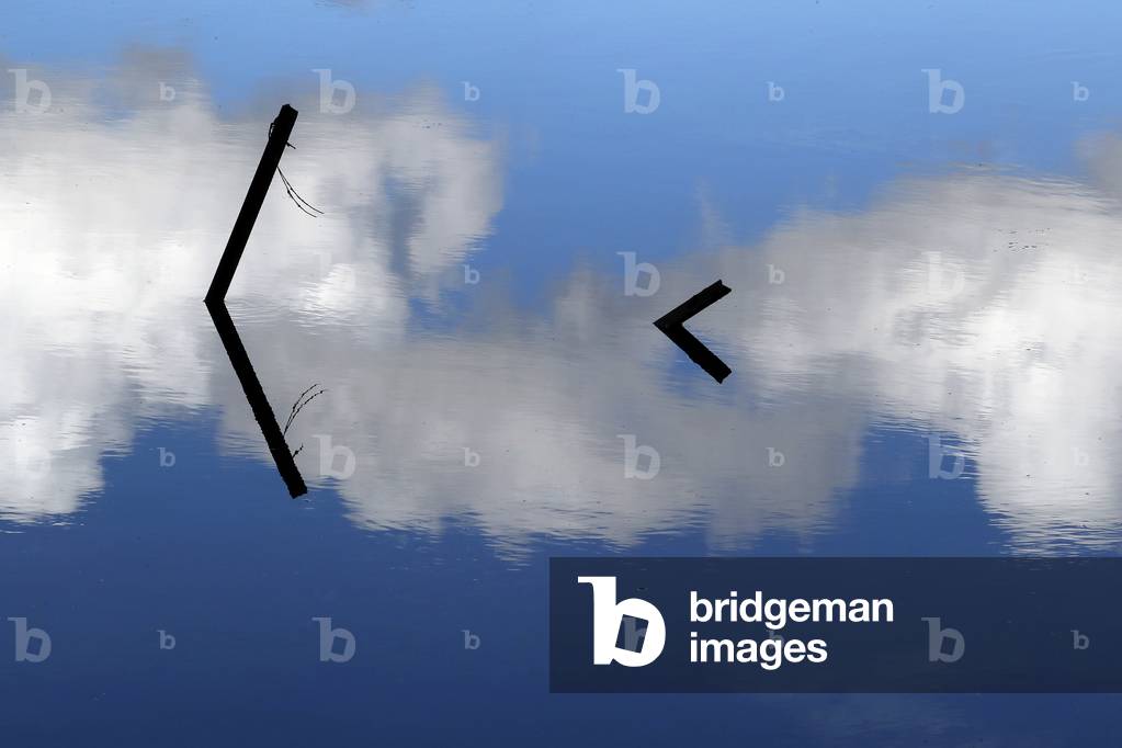 Clouds reflecting in water. France.