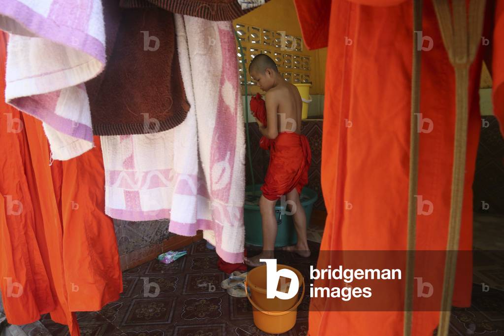 20151030, Vientiane, Laos : Wat Si Muang ( Simuong) buddhist temple. Novice buddhist monk washing orange robes