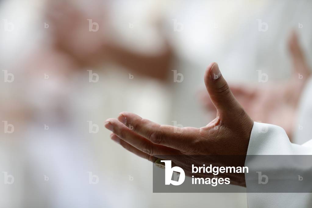 Catholic church during covid-19 epidemic.  Celebration of the mass. Priest praying.  Close-up on hands.  Sanctuary of La Benite Fontaine. France.