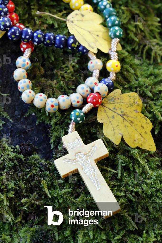 Catholic church. Wooden rosary with autum leaves.  France.
