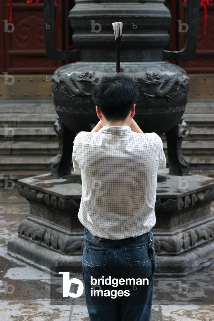 Prayer with incense in the Shanghai White Jade Buddha temple, Shanghai, Chine