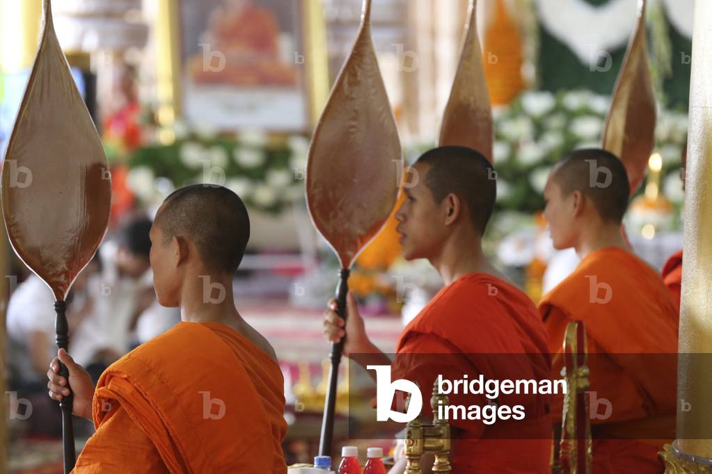 20151105, Vientiane, Laos : Wat Ong Teu buddhist temple. Seated Buddhist monks chanting and reading prayers at a ceremony