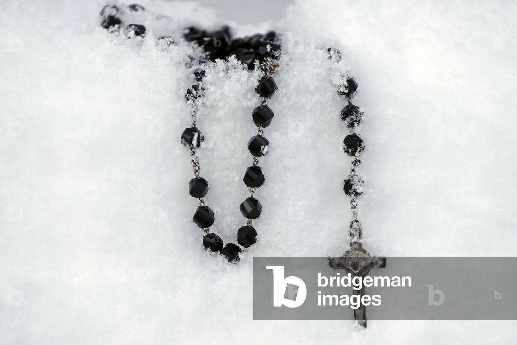 Christian rosary in snow.  France.  (photo)