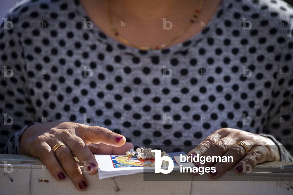 Woman with Rosary in hand before Pope Francis's Holy Mass in St. Peter's Square, at the Vatican.