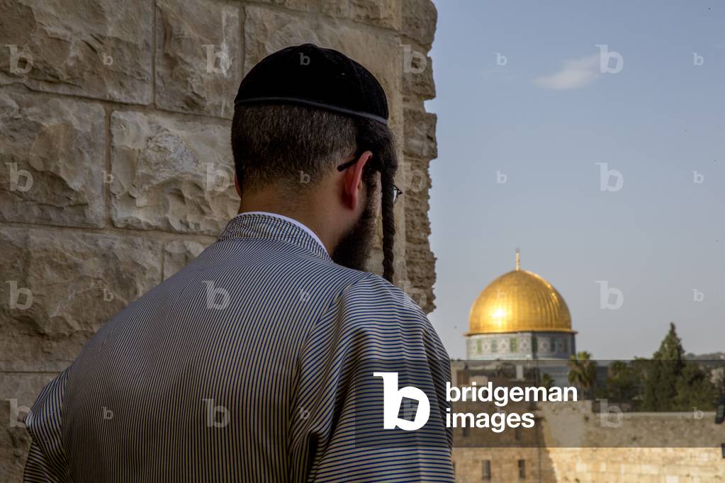 Orthodox jew looking at the Western wall and Dome of the Rock, Jerusalem, Israel. (photo)