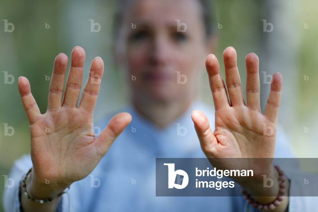 Woman practicing Qi Gong or Tai Chi exercise   in nature. Close up on hands.  France.