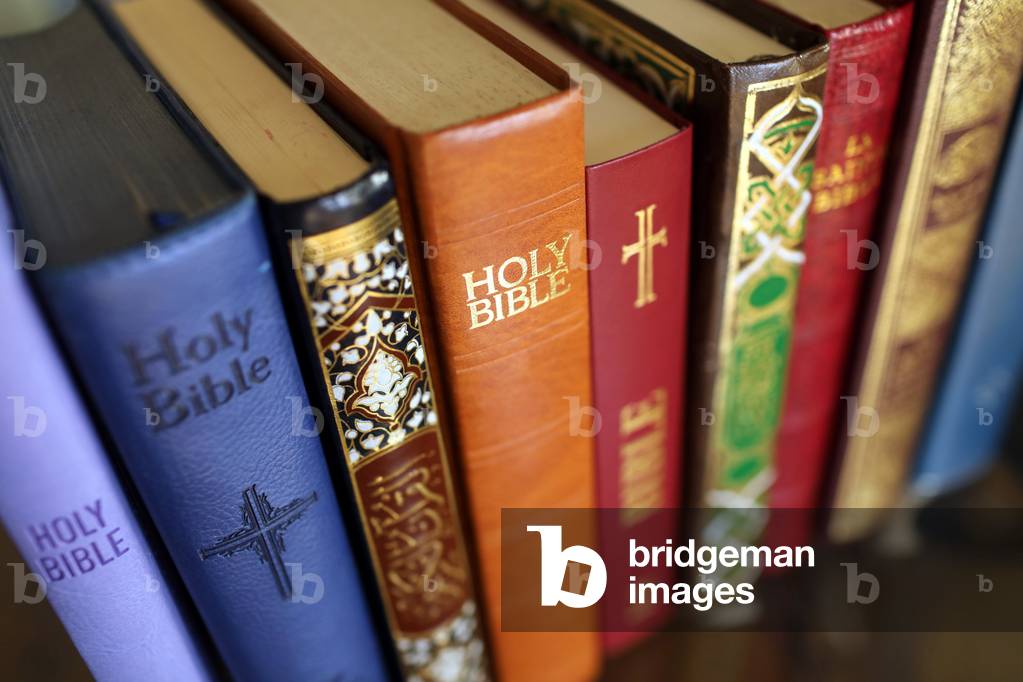 Stack of holy books : Bible and Quran. Christianity and Islam.