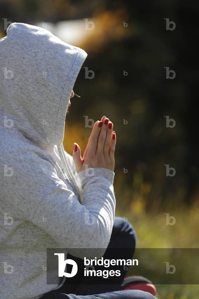 Christian woman praying in the forest.  Autumn.  France.