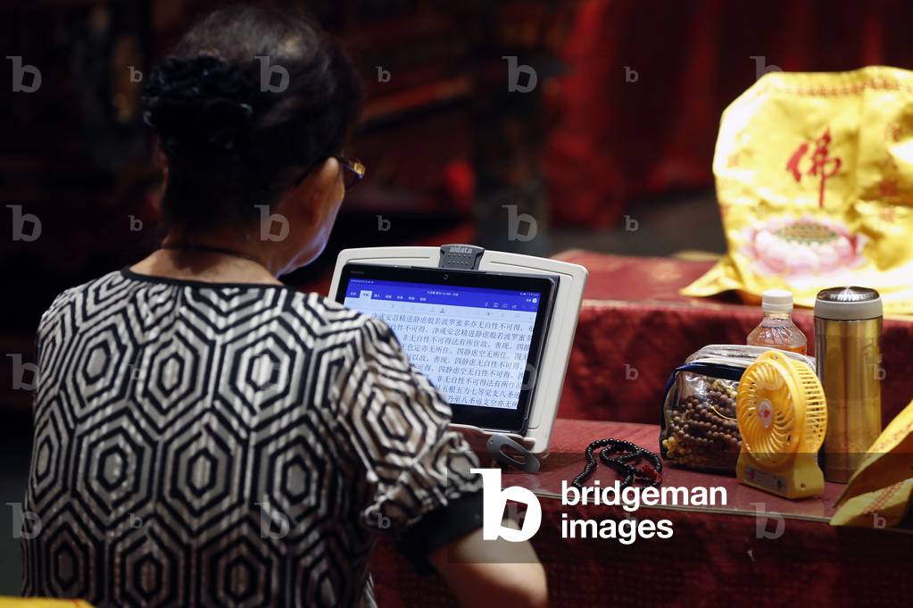 Buddha Tooth Relic Temple in Chinatown, Woman at  Buddhist ceremony,  Singapore,  2018 (photo)