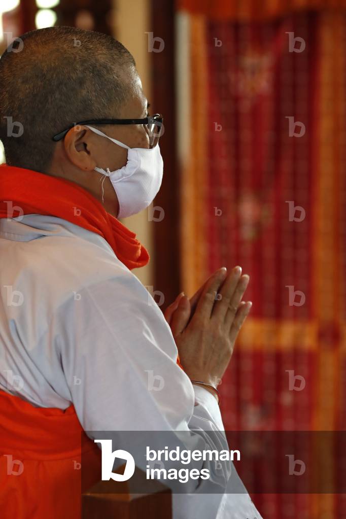 Tu An Buddhist temple. Monk with surgical mask at buddhist ceremony. Covid-19.  France.