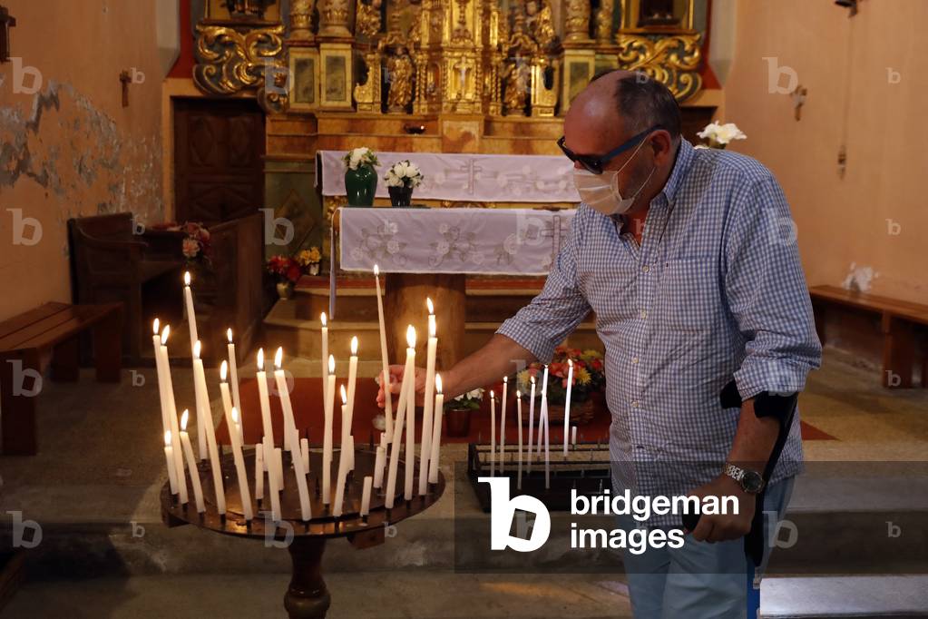 Notre Dame de la Gorge church. Man praying. Church candles.  France.