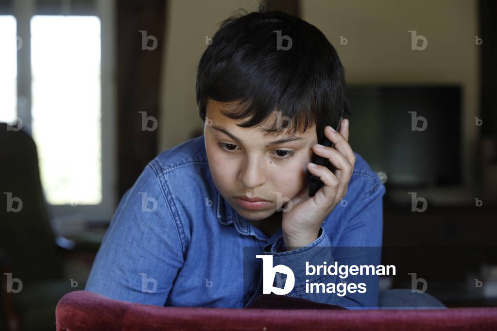 Boy with cell phone. Eure, France.