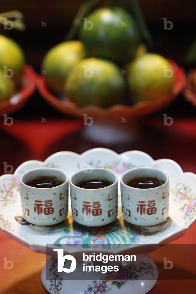 Khanh Van Nam Vien Taoist pagoda, Altar with offerings, Tea and fruits, Ho Chi Minh City, Vietnam, 2019 (photo)