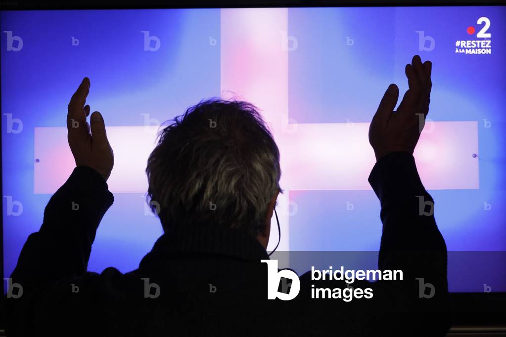 Coronavirus (COVID-19) epidemic, Containment measures, Man watching protestant service on television, France (photo)