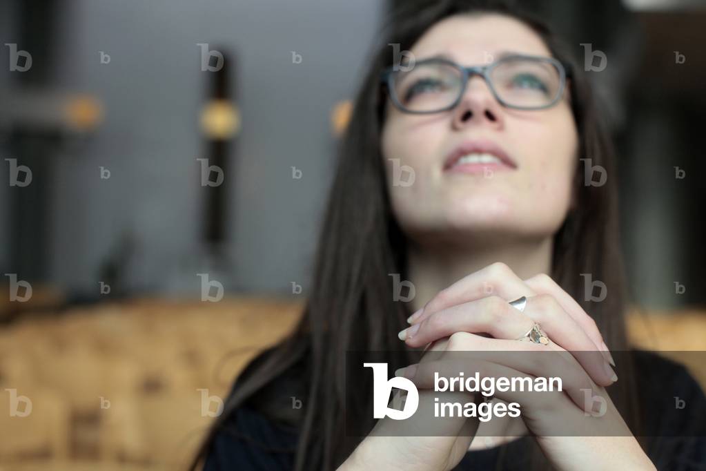 Young woman praying in a church ; Paris France