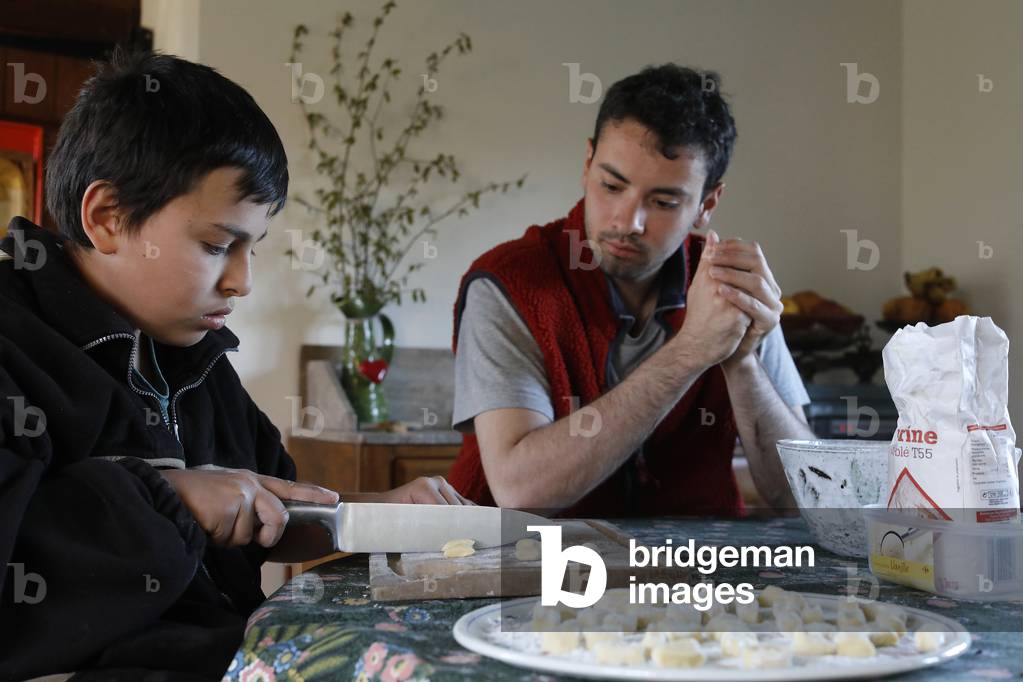 Young man showing his younger brother how to make gnocchi. Eure, France.
