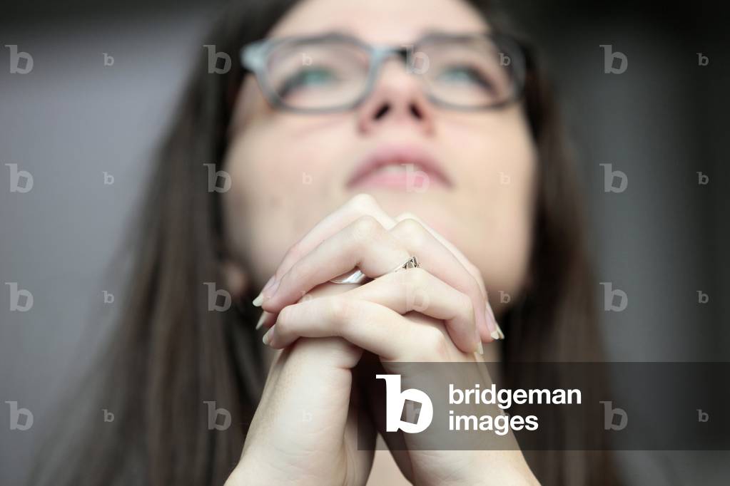 Young woman praying in a church ; Paris France