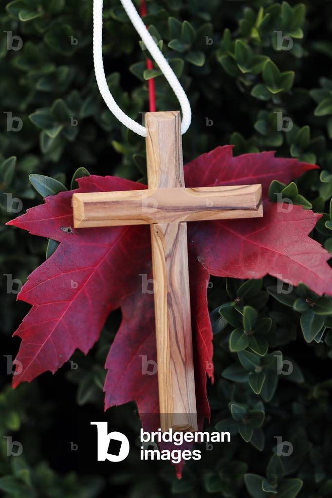 Christian wooden  cross on fall red  leaf. Autumn.  France.