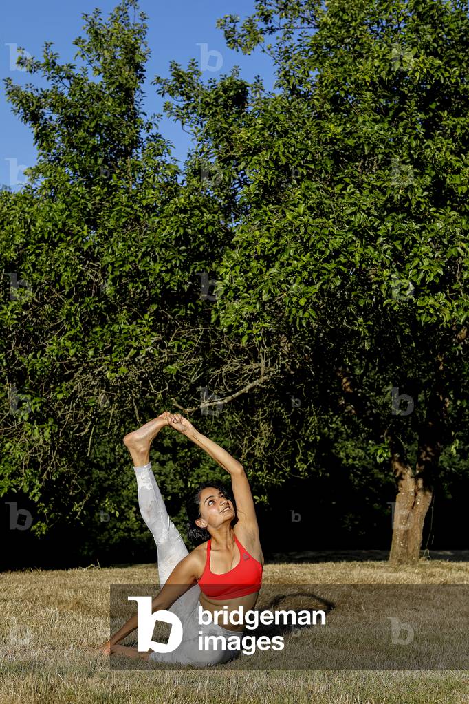 Young woman doing yoga in a garden in Eure, France