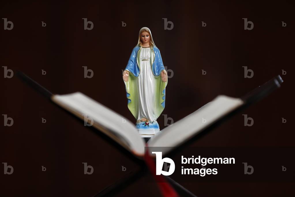 Virgin Mary figurine on an open Bible. France.