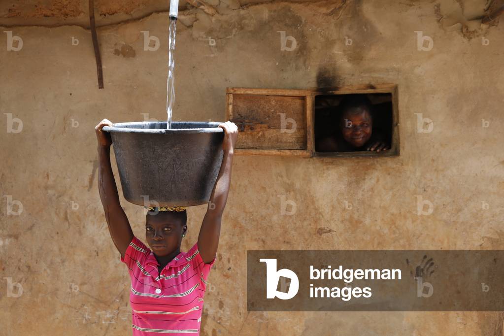 Collecting water in a Zou province village, Benin, Africa (photo)